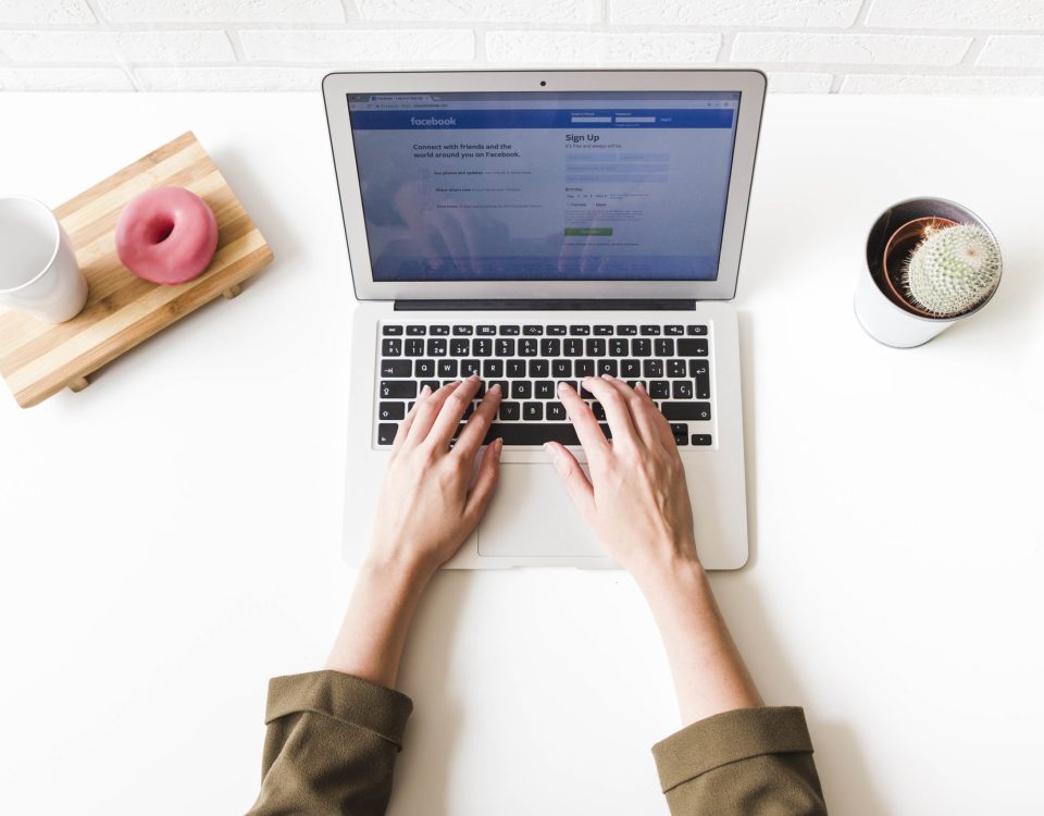 woman using facebook social site on laptop scaled 1