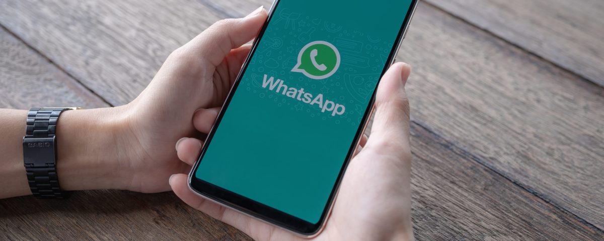 man holding smartphone with open whatsapp screen scaled 1