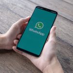 man holding smartphone with open whatsapp screen scaled 1