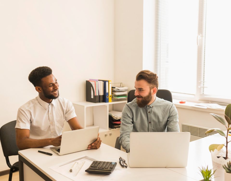 hommes utilisant ordinateurs portables bavardant